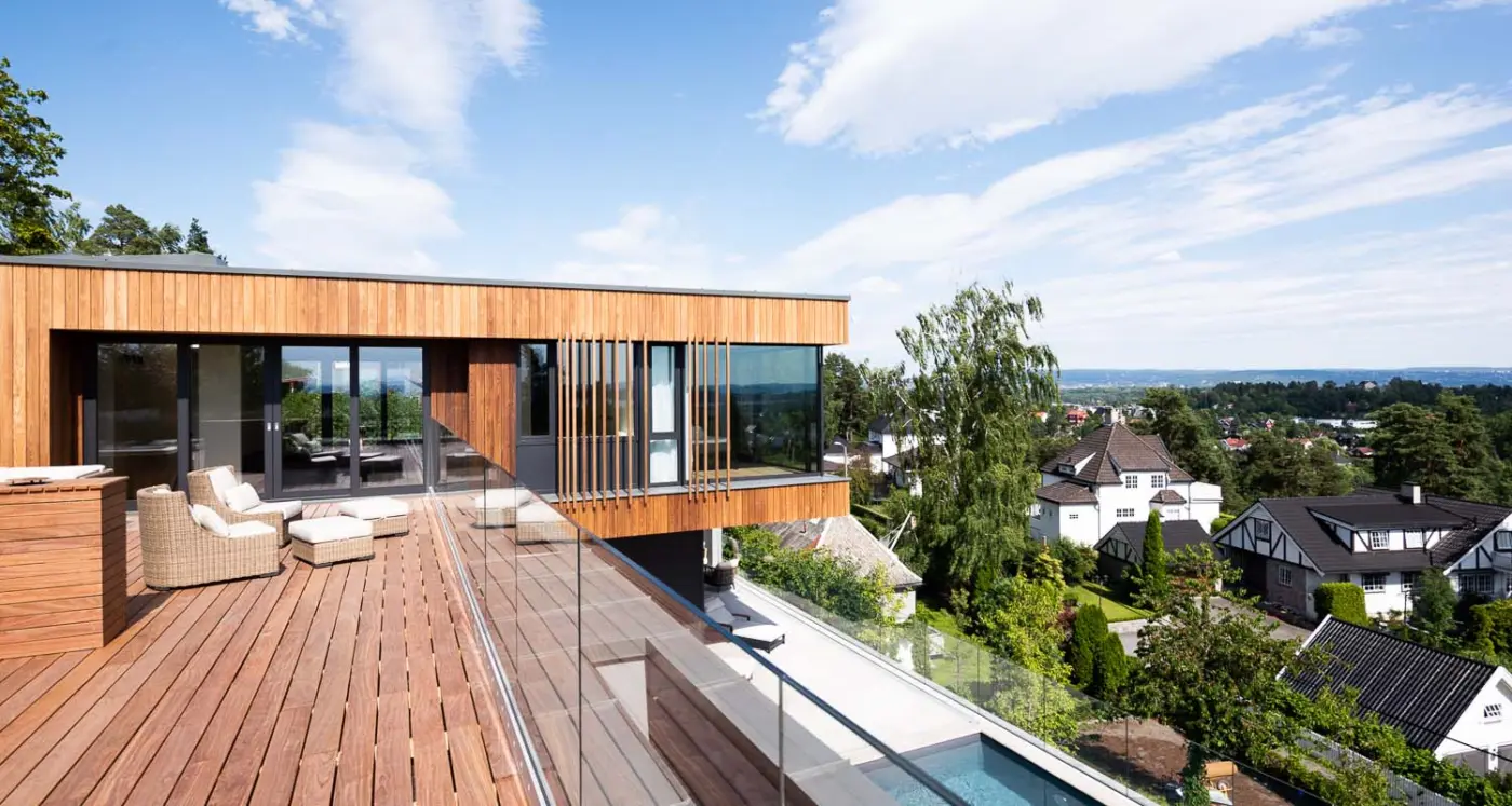 ÅSV28 — takterrasse i tre med loungemøbler, med utsikt over villabebyggelsen og fjorden