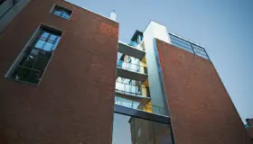 HAU16 — teglfasade sett nedenfra, med balkonger i en innskåret sjakt mellom bygningsvolumene