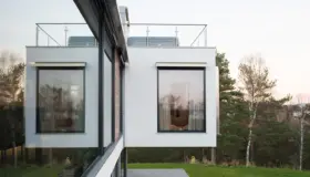 KAL15 — hvitpusset bolig med utkragede volumer og takterrasse, i bjørkeskog