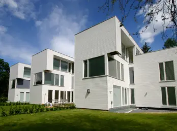 DLV — boliger i hvit liggende trekledning, satt sammen av forskjøvne volumer, med hage