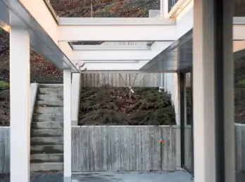 PLV17 — hvit pergola over uteplass, med murer i forskalingsbetong og trapp opp i hagen