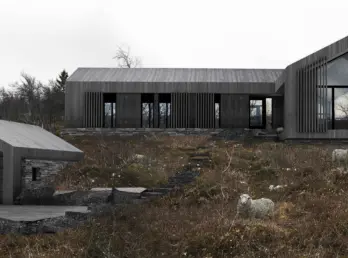 UVD1 — hytte i mørk trekledning med gavlvindu og spilefelt, med frittliggende garasje, på snaufjell med sau. Illustrasjon